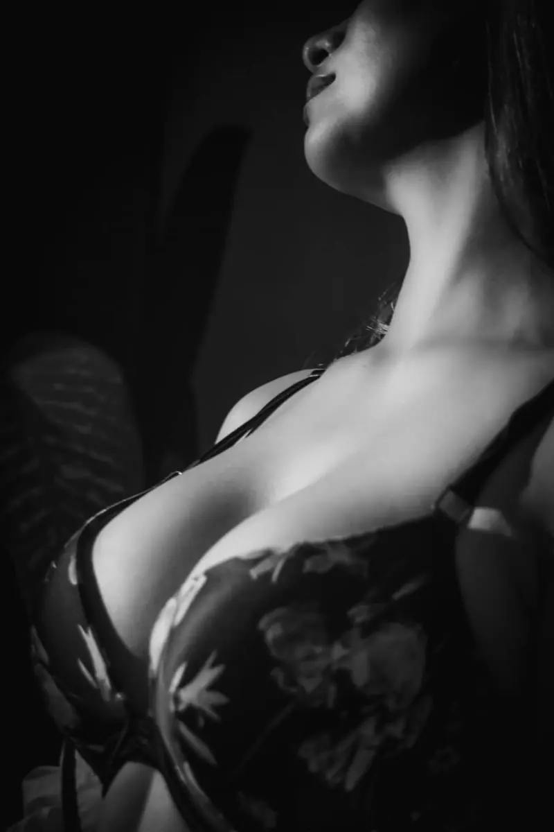 Detalle de torso superior con lencería negra y luz direccional